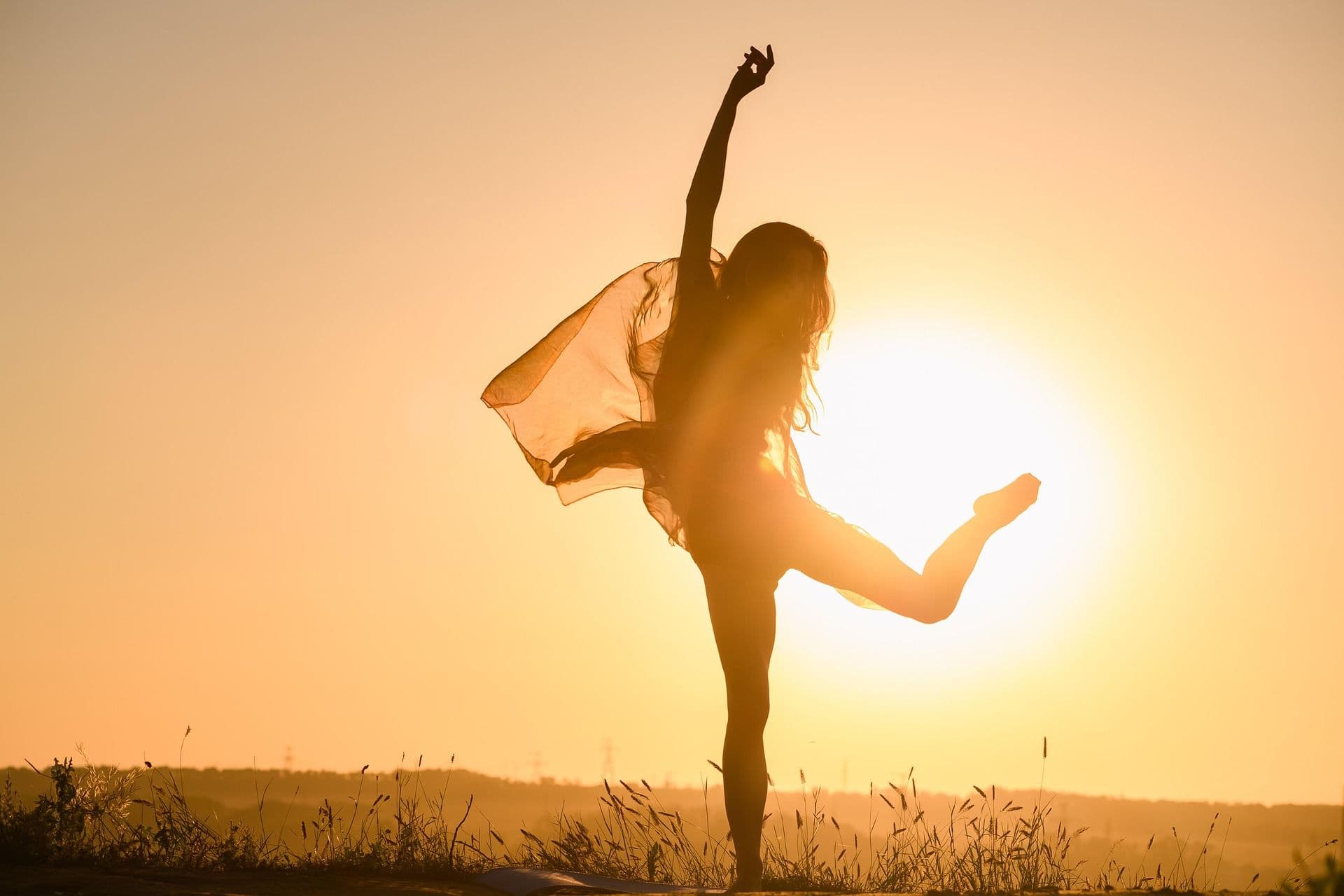 Woman doing yoga at sunset